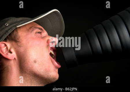Man singing in front of a snoot against a black background Stock Photo