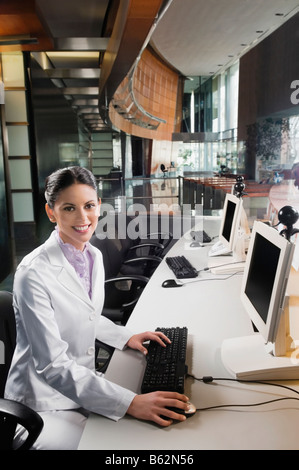 Portrait of a businesswoman working on a desktop PC and smiling Stock Photo