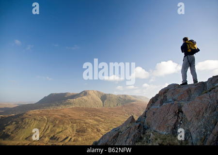 Hiker looking towards Devils Mother mountain from Leenaun Hill, Connemara, County Galway, Ireland. Stock Photo