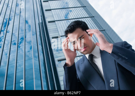 Low angle view of a businessman suffering from a headache Stock Photo