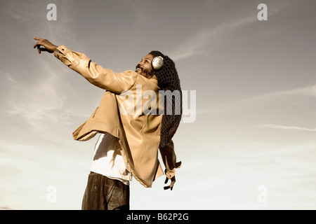 Low angle view of a mid adult man listening to music and dancing Stock Photo
