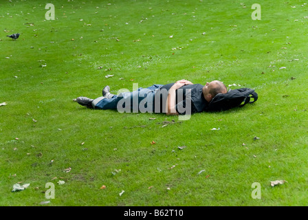 Man laying on grass enjoying the sun Stock Photo