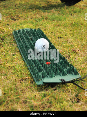 A golf mat for winter use and golf ball. Stock Photo