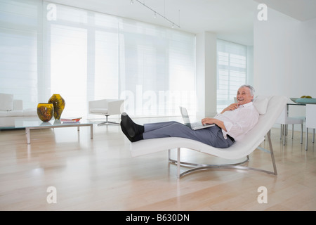 Senior man using a laptop and smiling Stock Photo