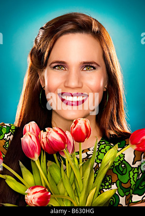 Portrait of a young woman holding a bunch of flowers Stock Photo