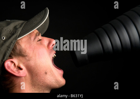 Man singing in front of a snoot against a black background Stock Photo