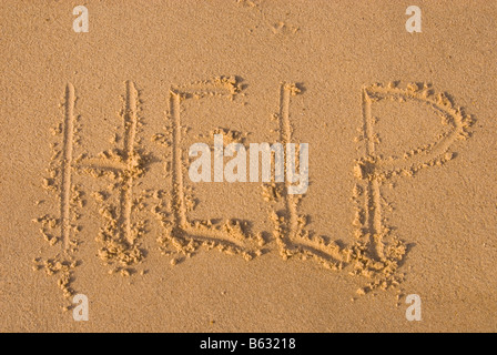 Help written in sand on beach Stock Photo