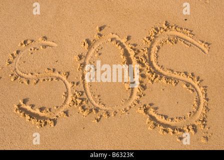 Sos written in sand on beach Stock Photo