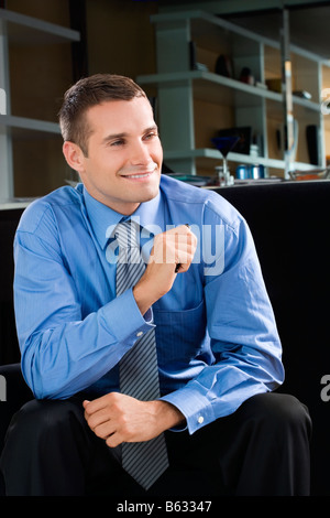 Young man sitting and smiling Stock Photo