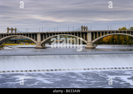 St Anthony Falls on the Mississippi river in Minneapolis with the Third Avenue bridge and inverted wave storm clouds Stock Photo