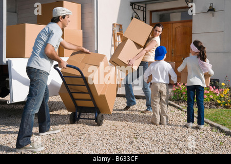 Couple with their children unloading goods from a pick-up truck Stock Photo