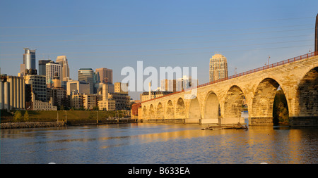 Panorama of Downtown Minneapolis highrise tower skyline and the Stone Arch Bridge on the Mississippi river at sunrise Stock Photo