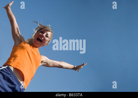 Portrait of a young woman jumping Stock Photo