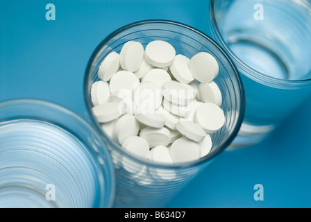Close-up of pills in a glass with two glasses of water Stock Photo