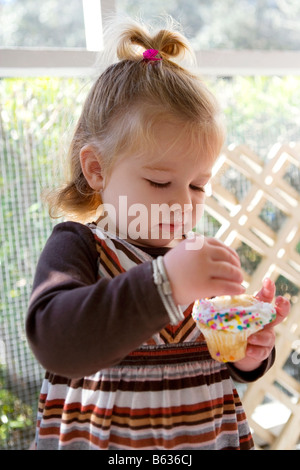 Close-up of a baby girl eating a cupcake Stock Photo