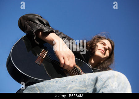 Low angle view of a young man playing the guitar Stock Photo