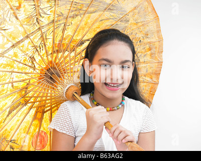 a pretty Asian girl smiling and holding a traditional oriental umbrella Stock Photo