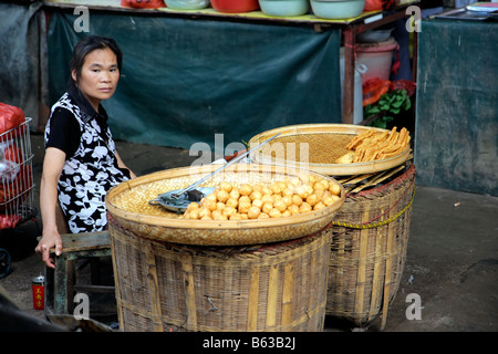 Chinese woman selling her fresh produce on a street market, Yangshuo, China Stock Photo