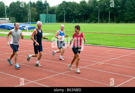Three man chasing a woman on a race track Stock Photo