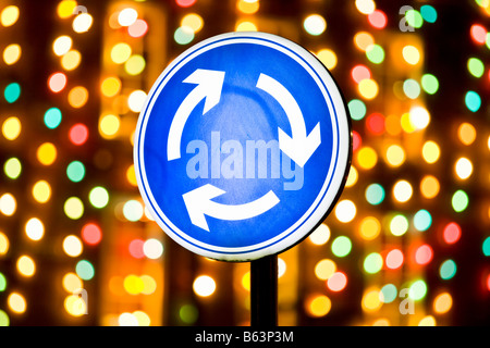 Traffic Island sign on Bridge Street in the Northumbrian town of Morpeth against a backdrop of Christmas lights in Market Place Stock Photo