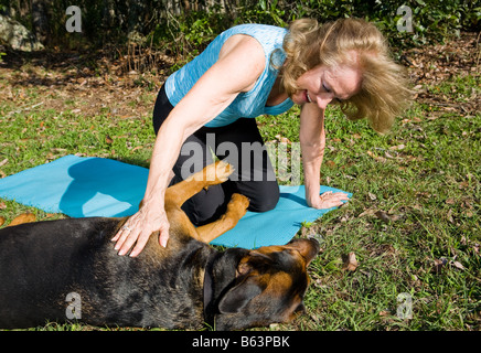 Beautiful mature woman playing with her dog outdoors Stock Photo