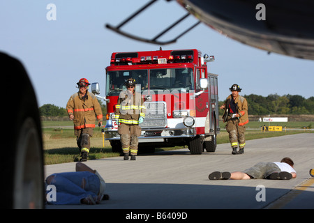 EMS and firefighter personnel have arrived to help people and assess the injured beneath an airplane at an airport in Wisconsin Stock Photo