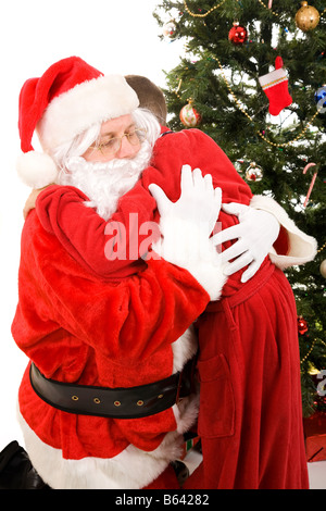 Santa Claus getting a big hug from a child on Christmas morning White background Stock Photo