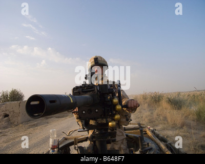 British Army soldier mans Grenade Machine Gun mounted on vehicle Stock Photo