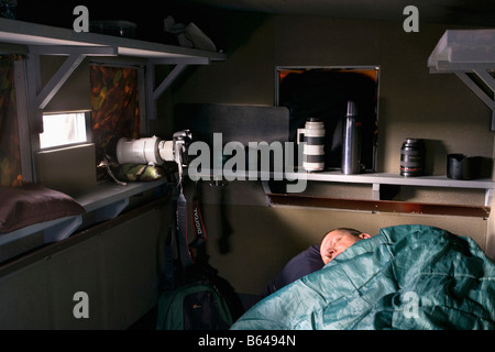 Finland, Ruhtinansalmi, near Suomussalmi, Photographer Frans Lemmens in hide sleeping. Stock Photo