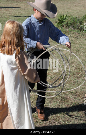 A young cowboy showing a little girl how to twirl the rope Stock Photo