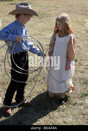 A young cowboy who has roped a cute young girl Stock Photo