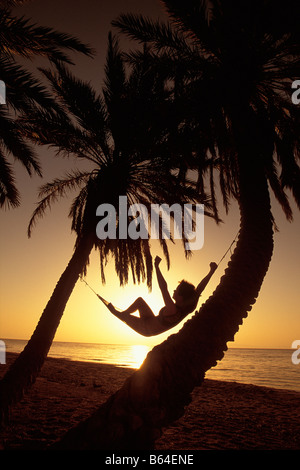 Egypt. Dahab at Red Sea. Tourist on beach relaxing in hammock. Stock Photo