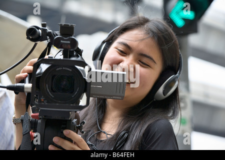 Young Thai woman shooting video on street, Bangkok, Thailand (during the 2006 coup) Stock Photo
