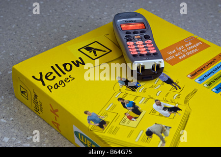 A phone on top of a Yellow Pages telephone directory Stock Photo