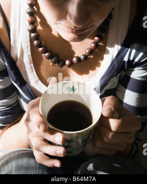 Young woman drinking mug of coffee Stock Photo