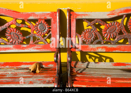 Two Red Painted wooden sun flower bench Stock Photo