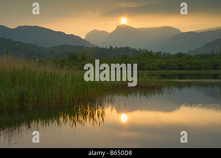 Hazy sunset over Elter Water and Langdale Pikes, Langdale Valley, Lake District National Park, Cumbria, England UK Stock Photo