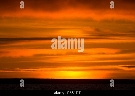 summer sunset glowingly reflected in clouds over a sea ice free Beaufort Sea 1002 area of the Arctic National Wildlife Refuge, North Slope, Alaska Stock Photo