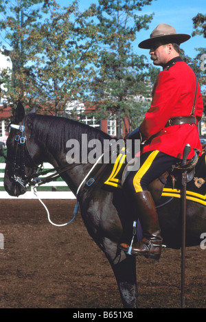 A Canadian Mountie (RCMP) Royal Canadian Mounted Police Officer riding on Horseback and wearing Traditional Red Serge Uniform Stock Photo