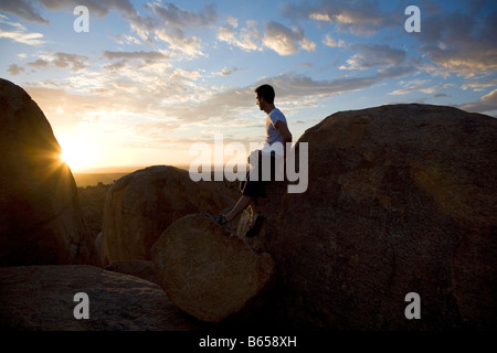 Canyon Lodge Moment - man leans against rock looking at sunset Stock Photo