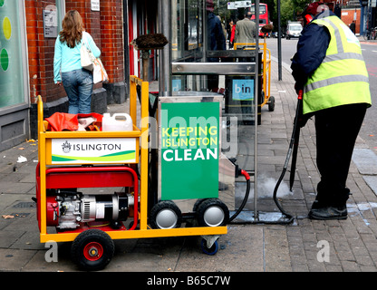 Council worker steam cleans chewing gum off pavement, London Stock Photo