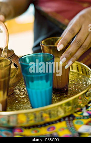 Milk tea being prepared in colored glasses on tea tray Stock Photo