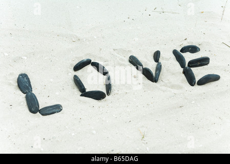 Pebbles spelling the word 'love' on beach Stock Photo
