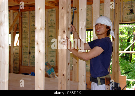 A young Japanese carpenter building a house Stock Photo