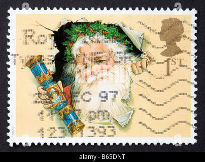 First class stamp with Father Christmas holding a Robin stuck on white ...