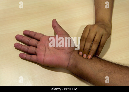 India, Mumbai, Maharashtra, Ayurvedic Therapy Center, Taking the pulse to analyse the physical problem of the person. Stock Photo