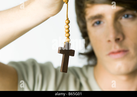 Young man looking at cross, close-up Stock Photo
