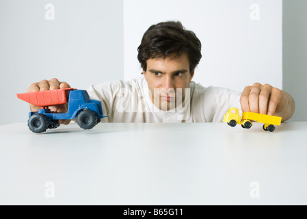 Man playing with toy trucks Stock Photo