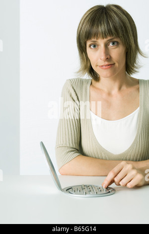 Woman playing peg solitaire game, smiling at camera Stock Photo