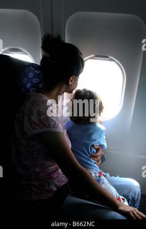 A Mother and her Child Looking out an Airplane Window Stock Photo